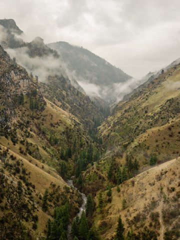 Misty mountain canyon with a river at the bottom